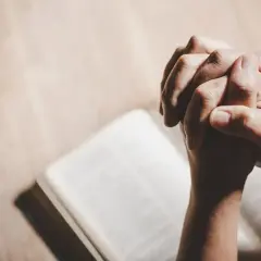 Dłonie złożone do modlitwy nad otwartą księgą. To modlitwa, która zawsze zostaje wysłuchana, pełna nadziei i wiary.