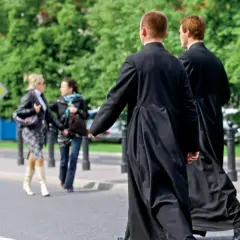 Dwóch księży w sutannach przechodzi przez ulicę, mijając dwie kobiety. Czy ksiądz może mieć żonę? To pytanie nurtuje wielu.