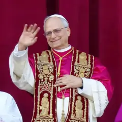 Nowy papież w bogato zdobionej szacie pozdrawia wiernych.