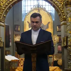 Duchowny w kościele polskokatolickim czyta z księgi. Różnice między kościołem polskokatolickim a rzymskokatolickim są widoczne w wystroju.