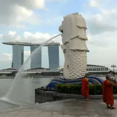 Mnisi w pomarańczowych szatach przy Merlionie, symbolu Singapuru, gdzie religia jest ważną częścią kultury.