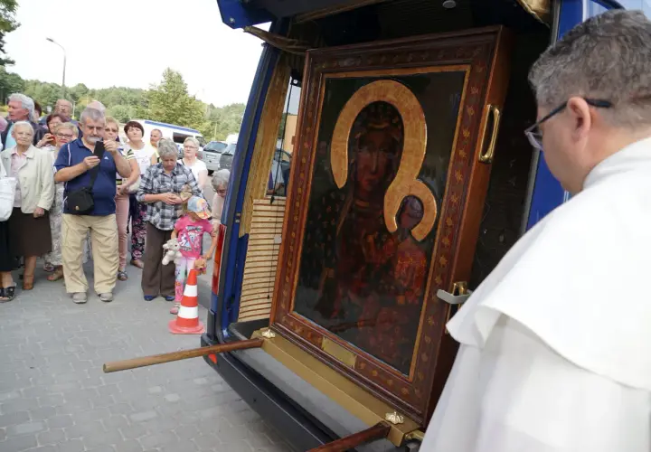 Obraz Matki Boskiej przygotowywany do peregrynacji. Ludzie zgromadzeni wokół, by zobaczyć święty wizerunek.