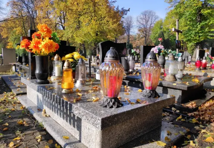 Znicze i kwiaty na grobie. Zastanawiasz się, jaka opłata za przedłużenie miejsca na cmentarzu parafialnym? Jesień na cmentarzu.