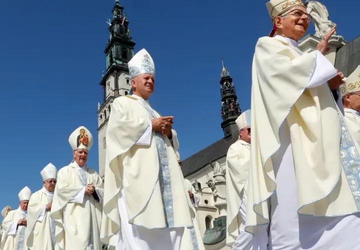 Biskupi w białych szatach procesyjnie idą pod jasnobłękitnym niebem. W tle widać wieże klasztoru, gdzie niedawno podpisano ważny konkordat.