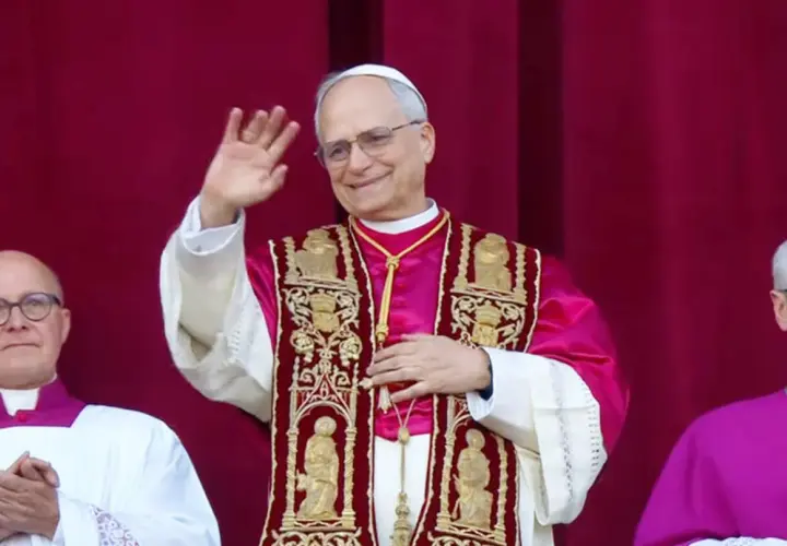 Nowy papież w bogato zdobionej szacie pozdrawia wiernych.