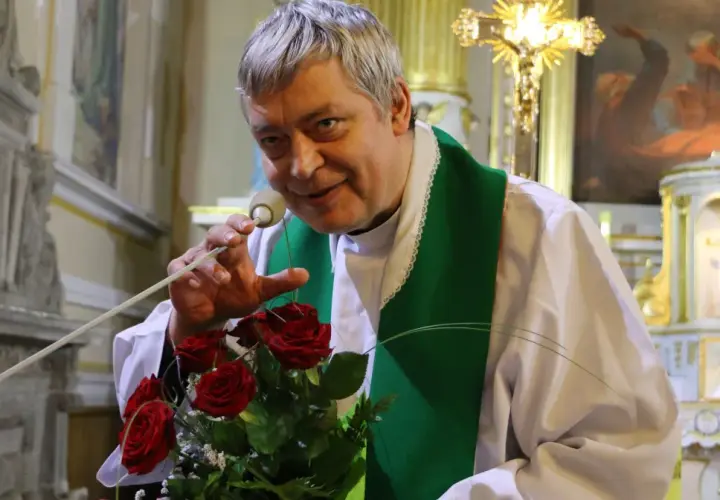 Ksiądz Piotr z bukietem róż, jak Piotr i Paweł, przemawia do wiernych w kościele.