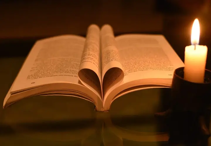 Serce z kartek książki, obok płonąca świeca. Czytanie psalm 9 w blasku ognia.