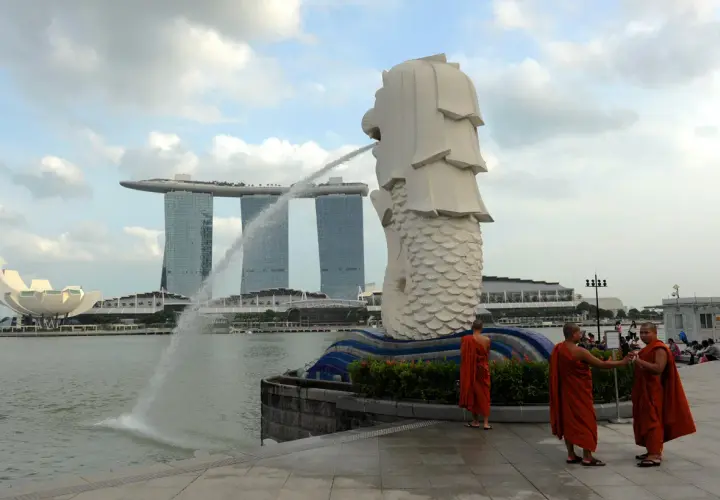 Mnisi w pomarańczowych szatach przy Merlionie, symbolu Singapuru, gdzie religia jest ważną częścią kultury.