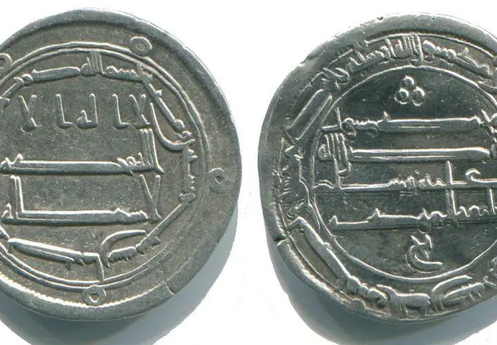 Dwie srebrne monety z arabskimi inskrypcjami, świadectwo bogatej historii mahometanizmu.