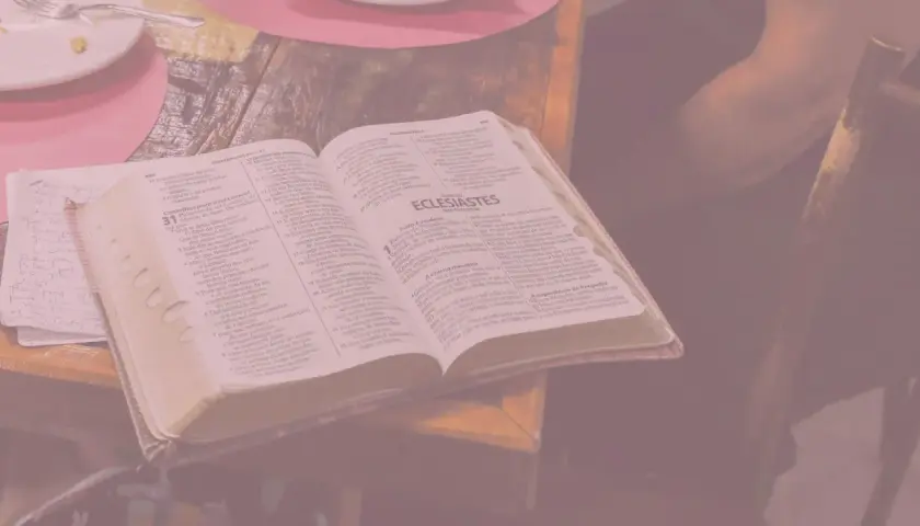 Otwarta księga z tekstem biblijnym, obok notatki ręczne. Wszystko to przypomina o marności nad marnościami, przemijaniu.