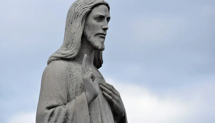 Kamienna rzeźba Jezusa z podniesionym palcem, jakby w geście błogosławieństwa lub modlitwy za rodziców.