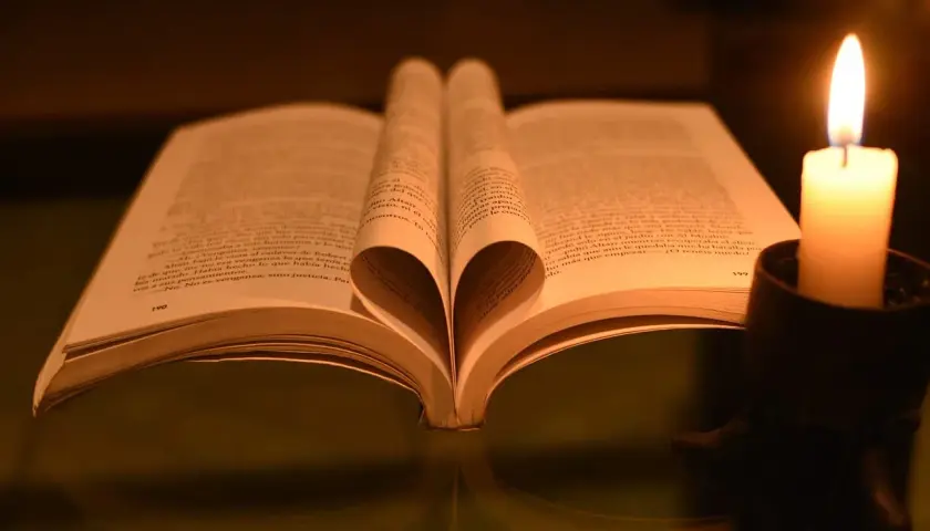 Serce z kartek książki, obok płonąca świeca. Czytanie psalm 9 w blasku ognia.