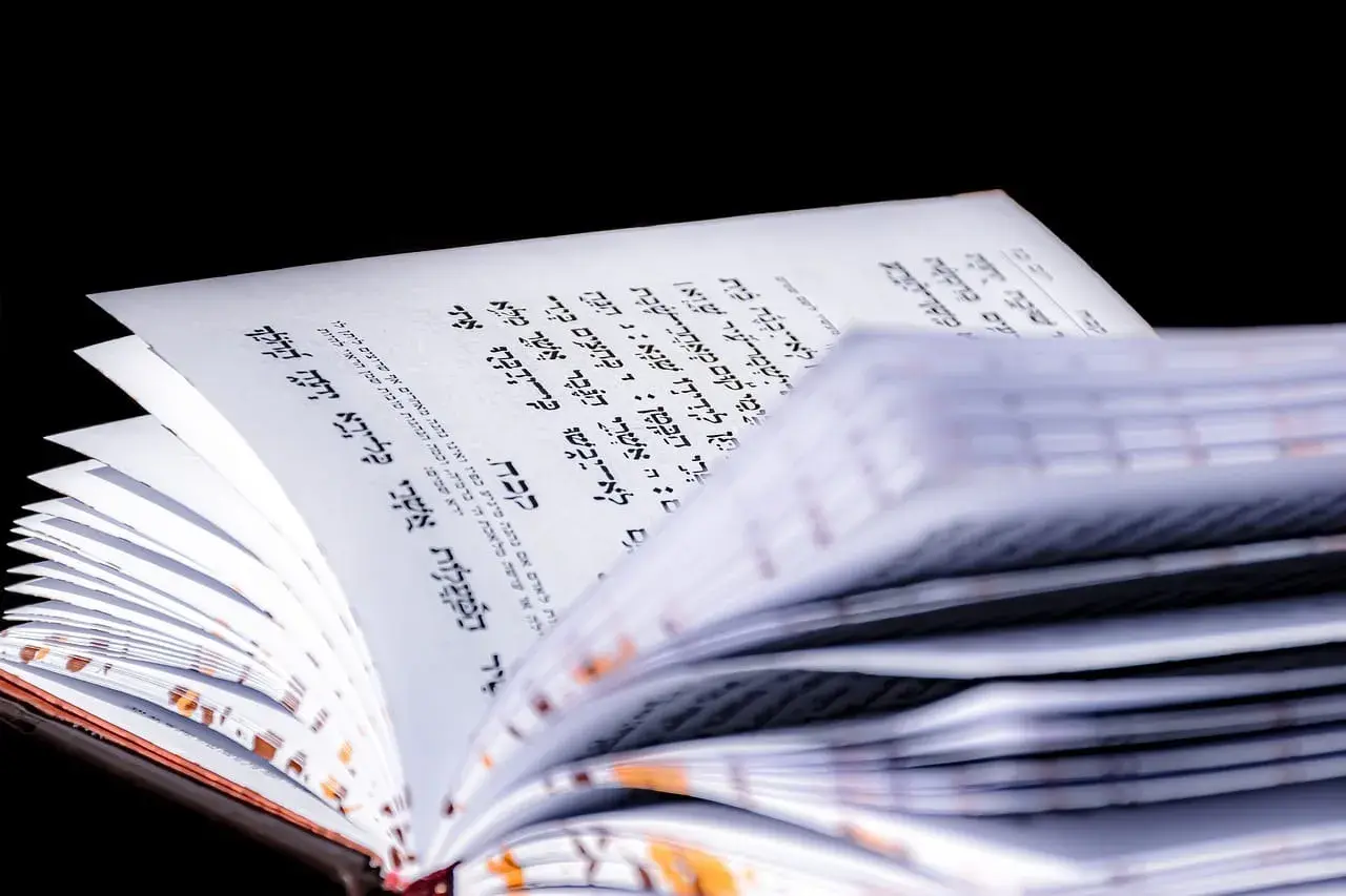 Otwarta księga z tekstem hebrajskim, przypominająca psalm 137. Strony są lekko pożółkłe, a tekst zapisany czarną czcionką.