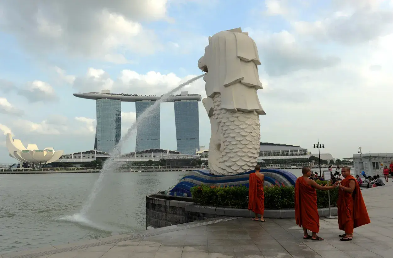Mnisi w pomarańczowych szatach przy Merlionie, symbolu Singapuru, gdzie religia jest ważną częścią kultury.