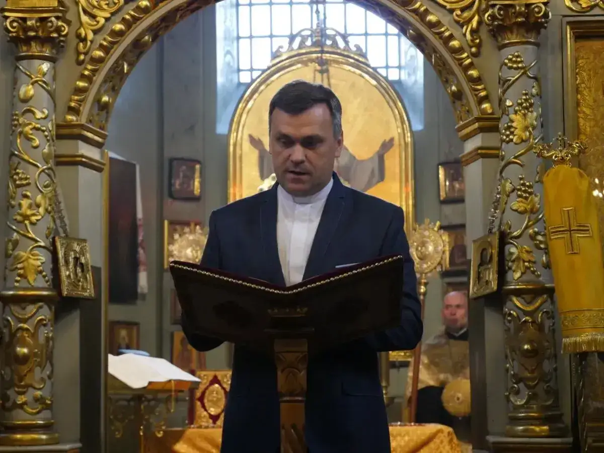 Duchowny czyta z księgi w bogato zdobionym kościele. Różnice między kościołem polskokatolickim a rzymskokatolickim mogą być widoczne w wystroju.