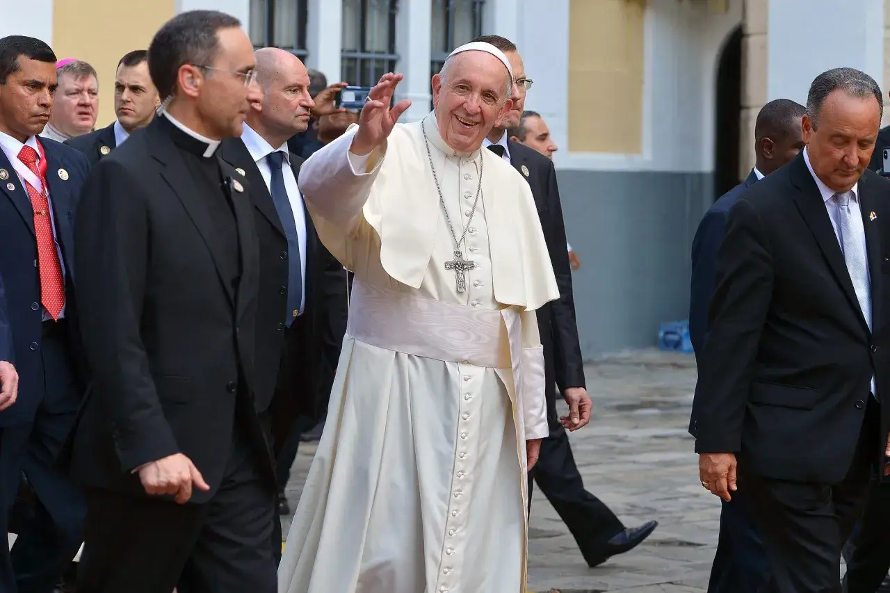 Papież Franciszek w białej sutannie, pozdrawia tłum. Jego pontyfikat to czas nadziei dla wielu.