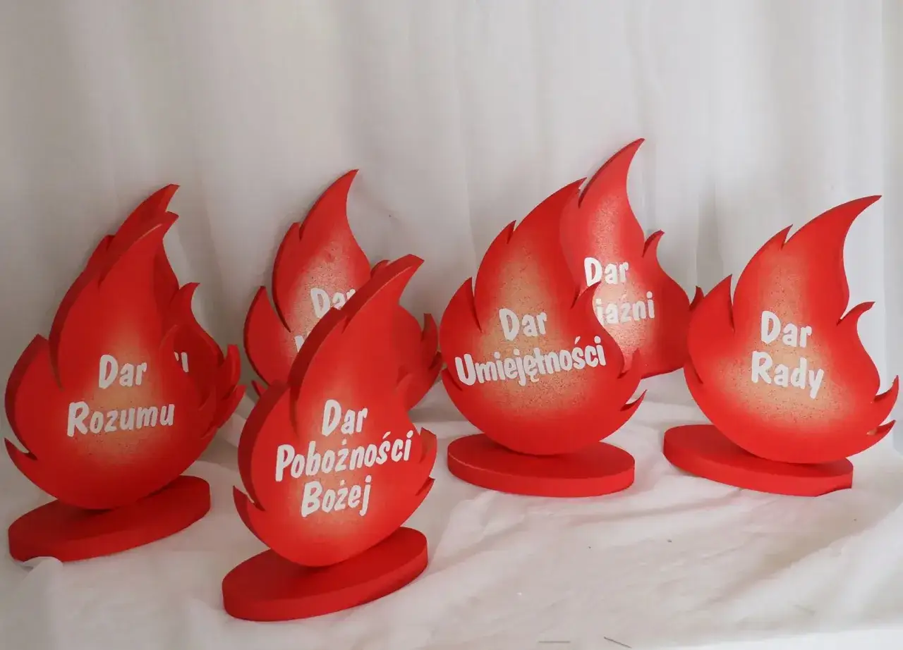 Osiem czerwonych płomieni symbolizuje 7 darów Ducha Świętego: Rozumu, Mądrości, Umiejętności, Rady, Pojednania, Męstwa i Bojaźni Bożej.